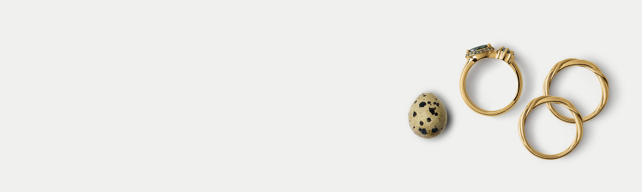 Group of wedding bands and an engagement ring by Alfonzo with a decorative egg