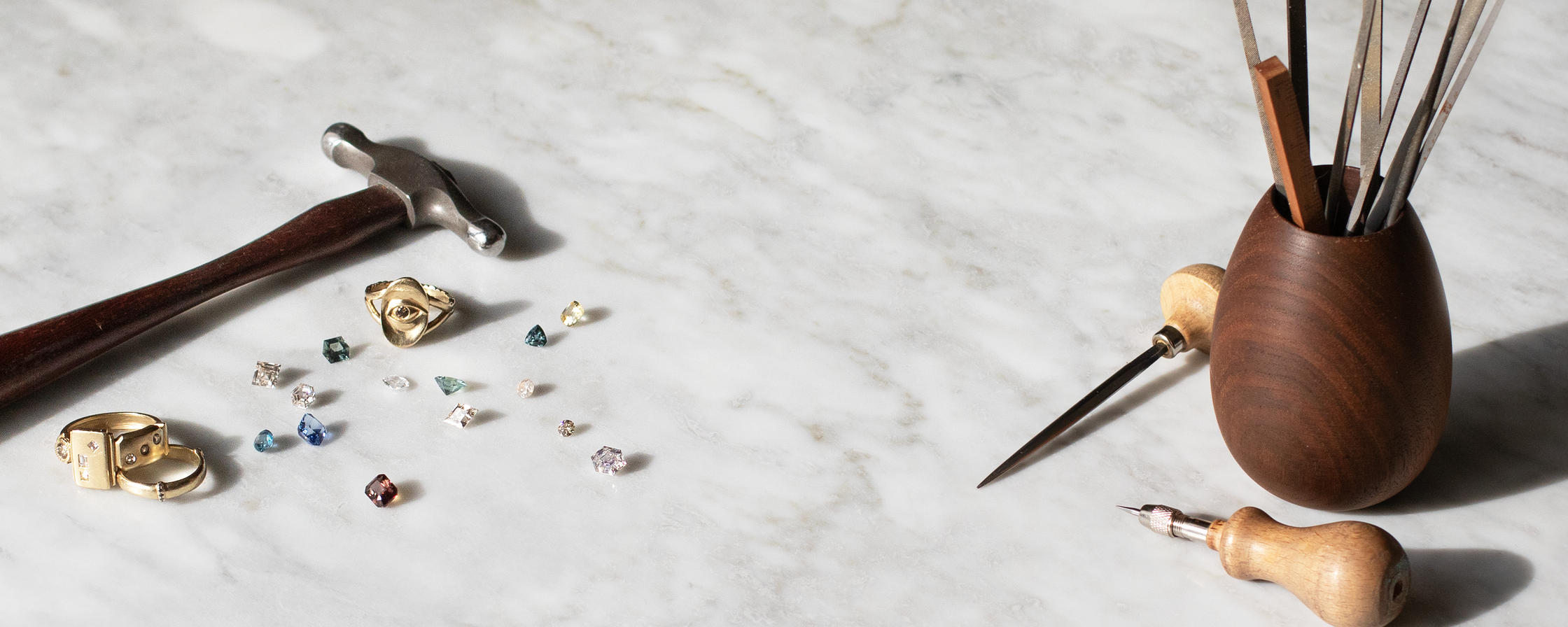 Gemstones, tools, and jewelry by Alfonzo on a marbile background