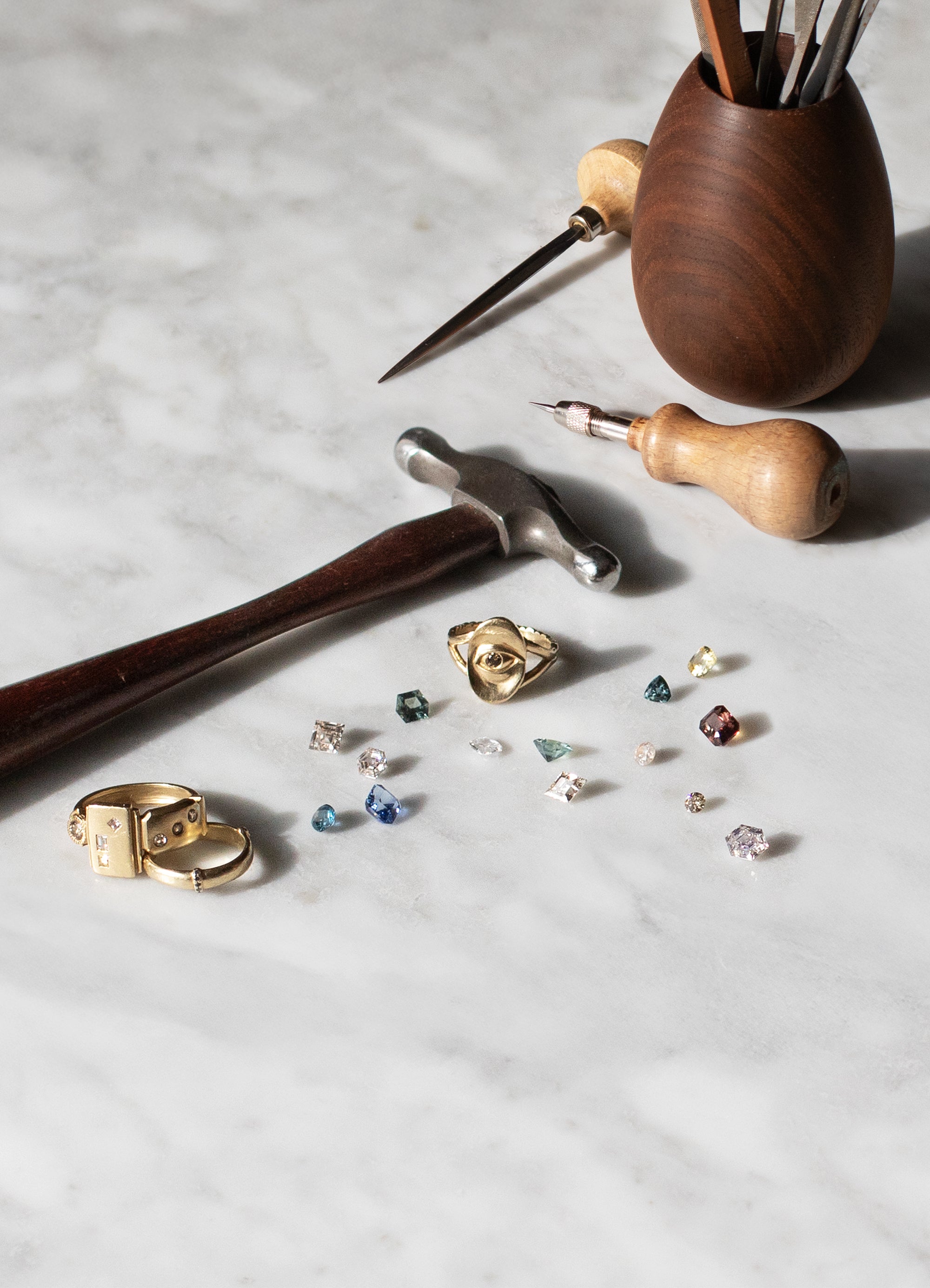 Gemstones, tools, and jewelry by Alfonzo on a marbile background