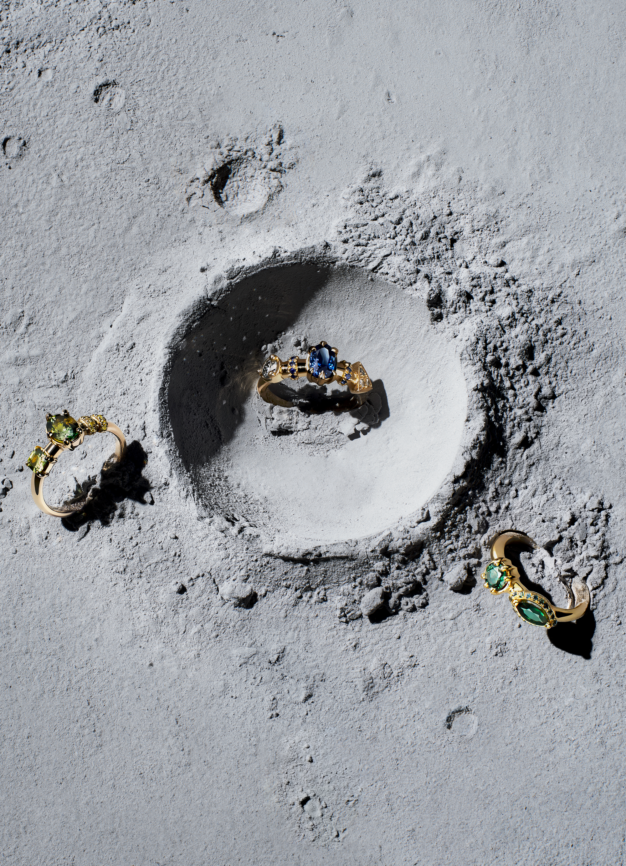 Three engagement rings on an abstract space like backdrop