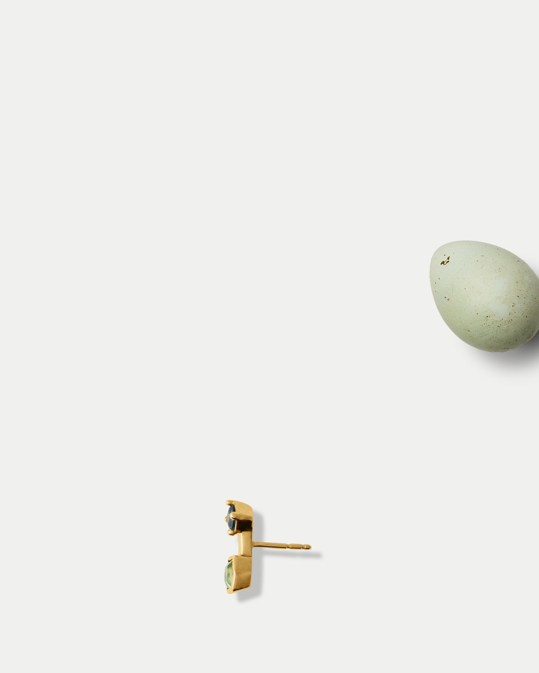 Side view of Canis Minor Stud ft. Green & Teal Sapphire in 14k yellow gold with an egg