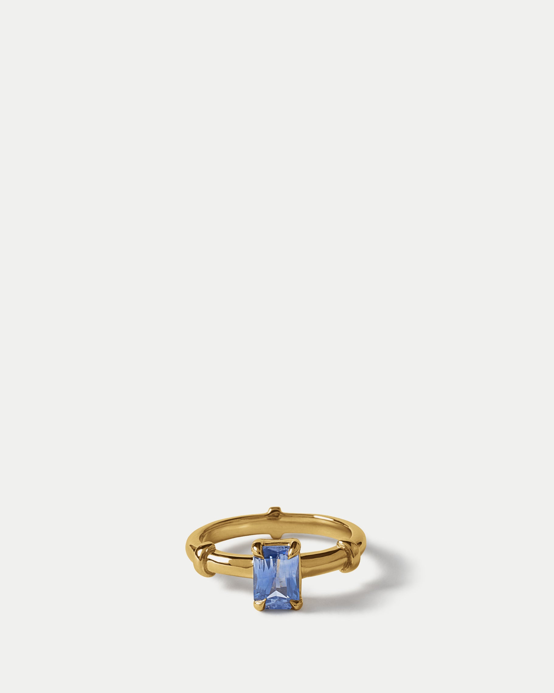 Angled view of Orion Solitaire Ring ft. Radiant Blue Sapphire in 14k yellow gold