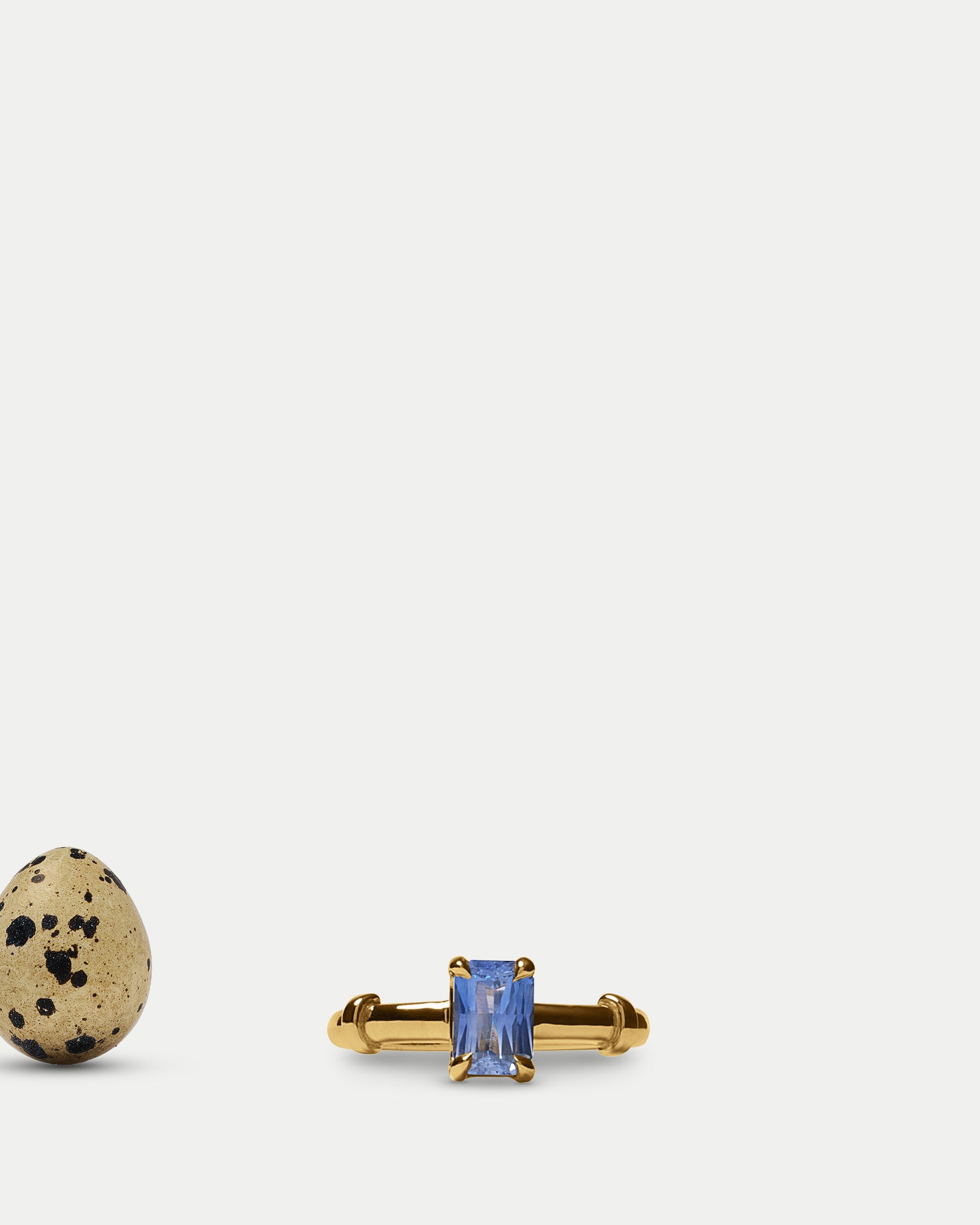 Front view of Orion Solitaire Ring ft. Radiant Blue Sapphire in 14k yellow gold with an egg
