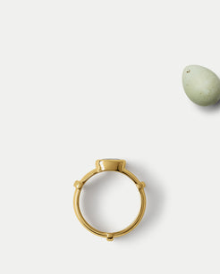 Flat lay view of Orion Solitaire Ring ft. Oval Blue Sapphire in 14k yellow gold with an egg